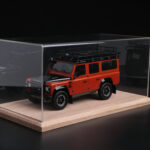 Red Land Rover Defender model car in a tabletop display case