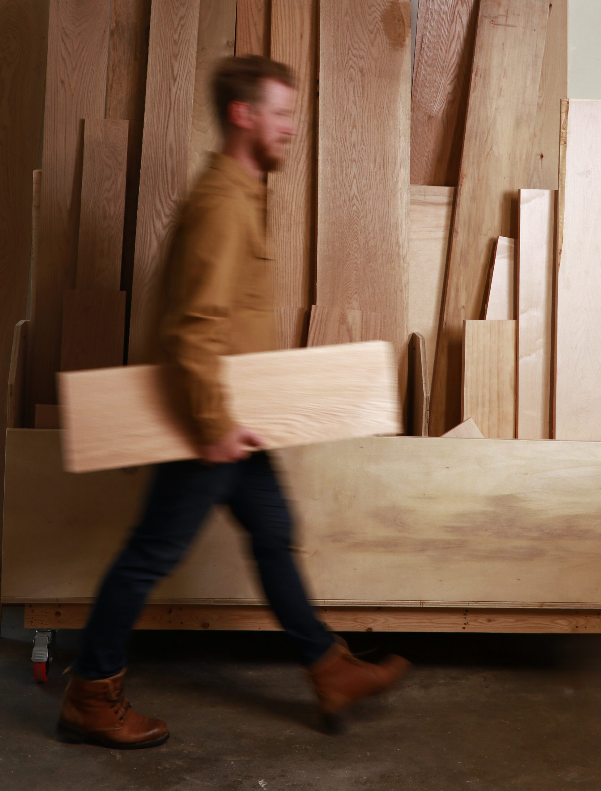 Craftsman measuring and marking wood pieces in the workshop