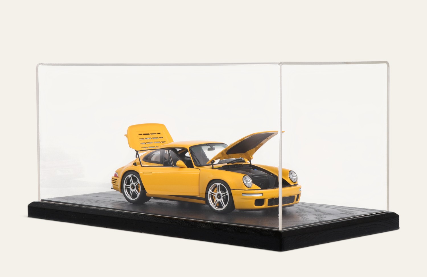 Black tabletop display case with a yellow Porsche model car, doors open