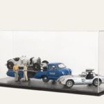 Black tabletop display case with a Mercedes-Benz race car transporter diorama