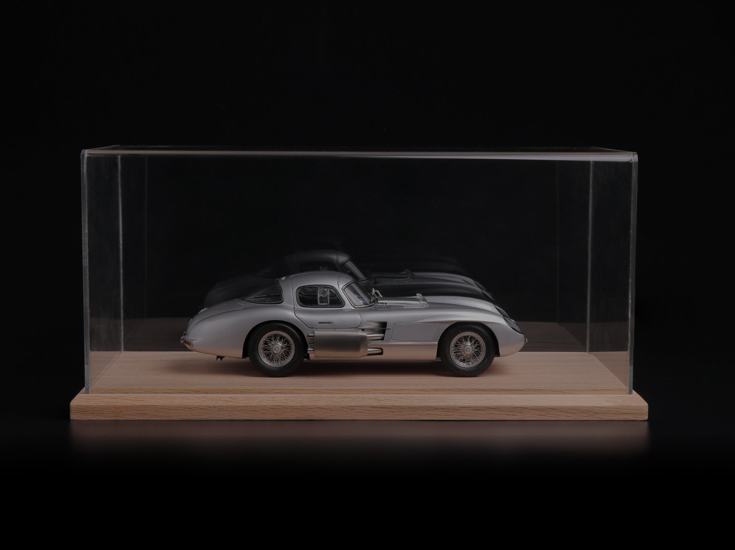 Silver Mercedes-Benz 300 SLR model car in a glass display case