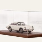 Walnut tabletop display case with a white vintage Porsche model car