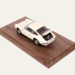 Cream Porsche model car on a walnut base, rear three-quarter view