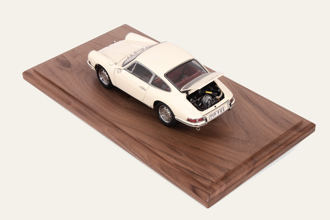 Cream Porsche 911 model car displayed on a walnut base