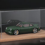 Green sports car model in a clear acrylic display case