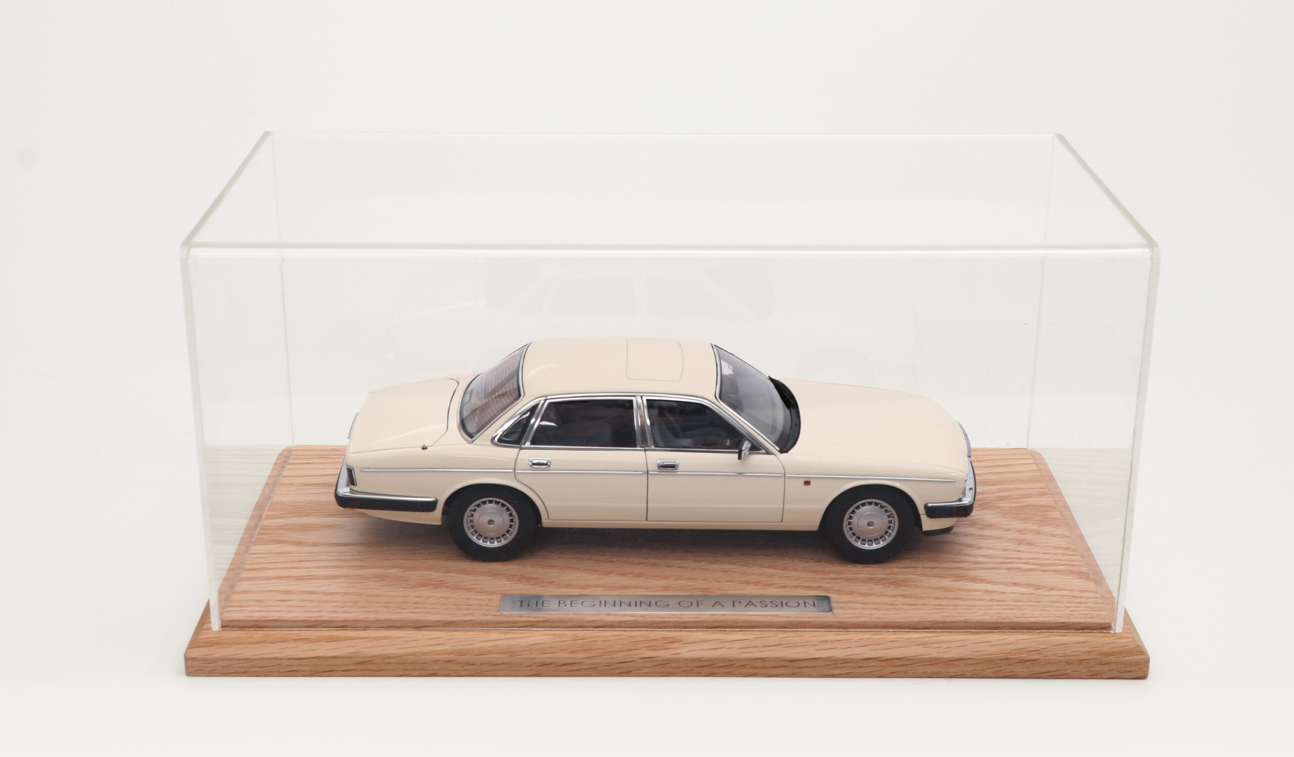 Cream model car enclosed in an acrylic-topped tabletop display case