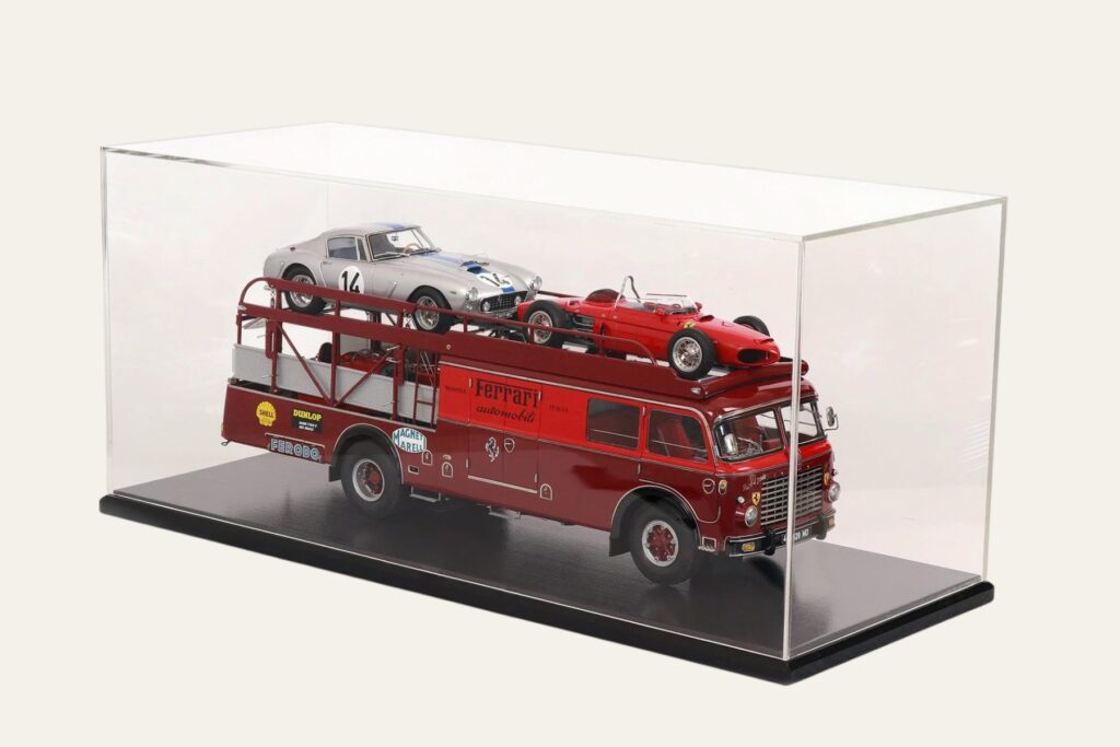 Ferrari car transporter model loaded with a race car in a black-based display case